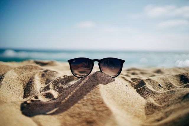 sunglasses-on-beach-sand-essential-things-to-bring-on-beach-vacation.jpg